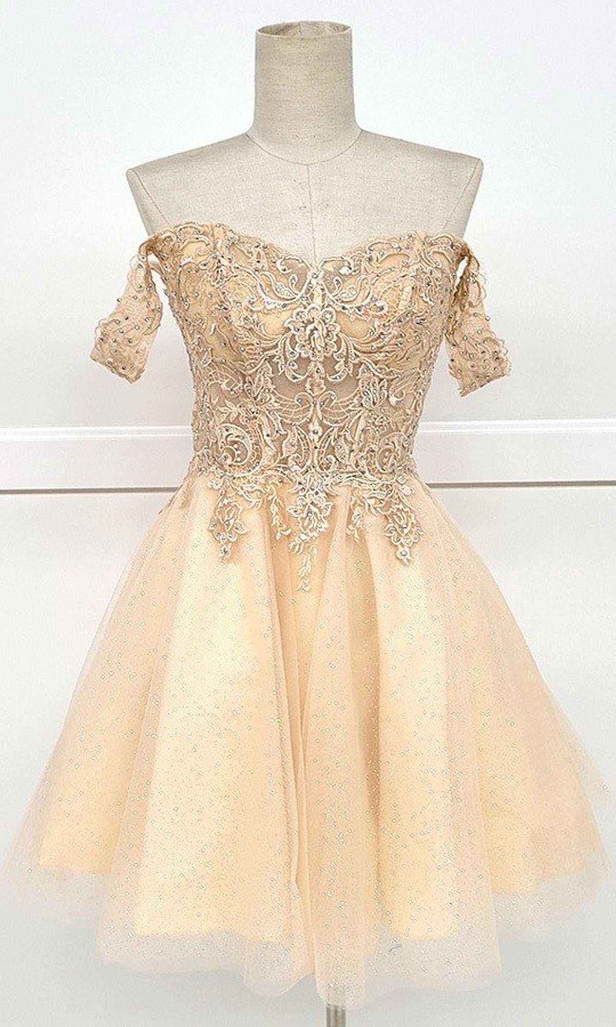 The Off-Shoulder Short Glitter Homecoming Dress C318 is a chic beige A-line cocktail dress with lace embroidery on the bodice and a flared tulle skirt, making it the perfect stylish option for any homecoming event.